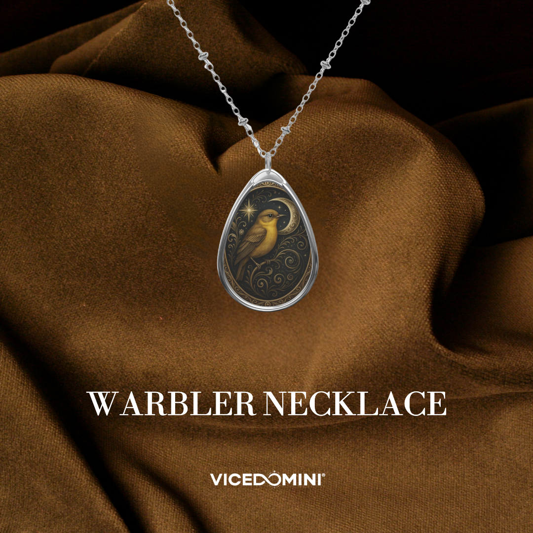 Warbler necklace resting on rich brown fabric, showcasing a golden bird with a crescent moon motif. The piece embodies the Warbler spiritual meaning and symbolic significance of inner voice, transition, and poetic beauty.