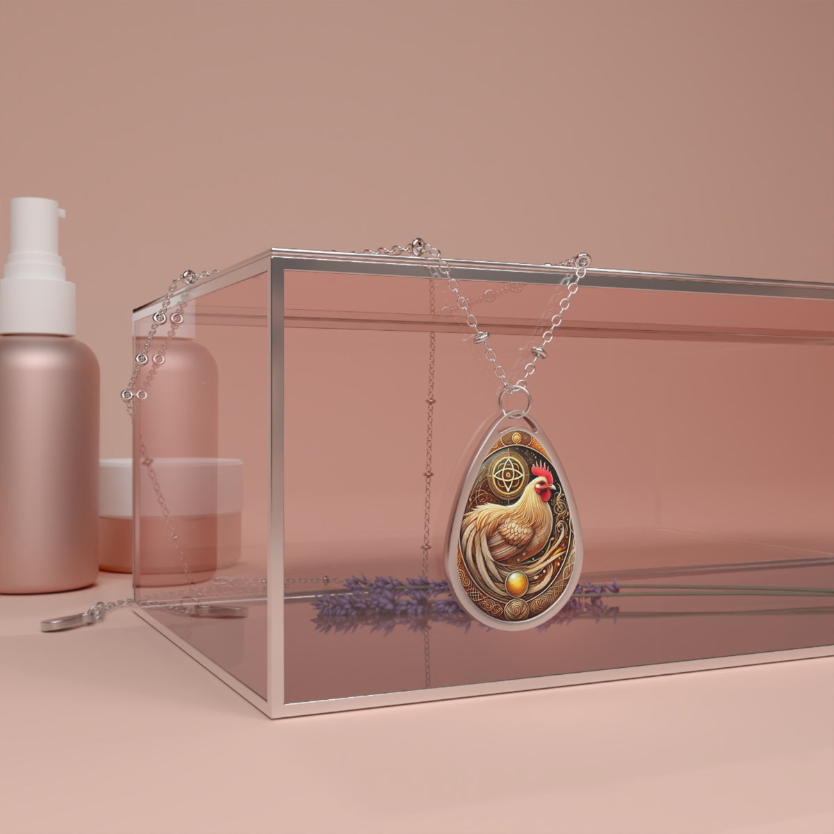 A cormorant-themed necklace with intricate gold and blue detailing hangs over a glass box with a soft pink background. The pendant features a black cormorant bird with an ornate swirling frame. A delicate silver chain drapes around the box, adding elegance to the scene.