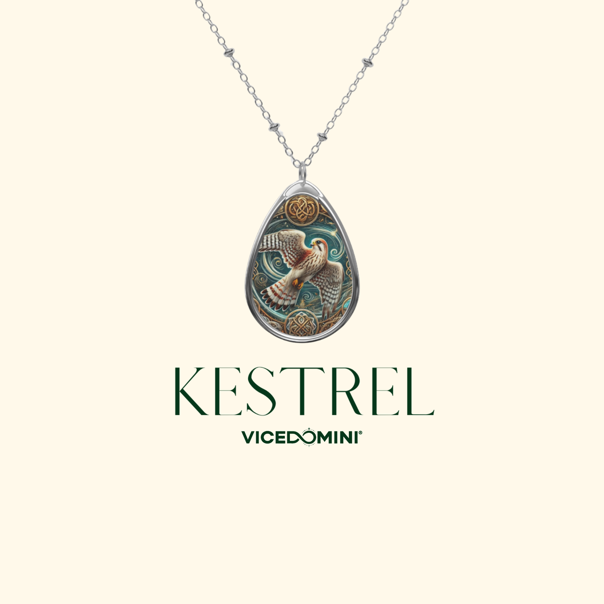 A Kestrel pendant necklace by Vicedomini, featuring a detailed bird illustration in teal, gold, and brown on a silver teardrop-shaped pendant, shown against a light cream background with the brand name below.