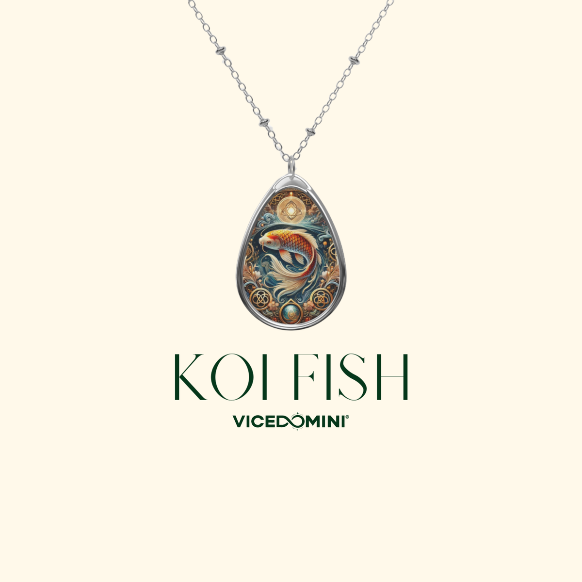 A silver-toned teardrop pendant necklace featuring a colorful fish illustration with gold, blue, and orange details, shown on a cream background with the text 'KOI FISH' and 'VICEDOMINI' below.