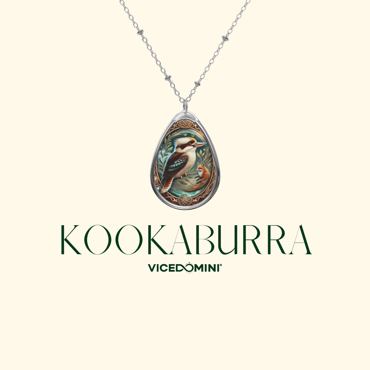 A teardrop-shaped pendant necklace featuring an illustrated kookaburra bird in a silver-toned frame, suspended from a delicate silver chain against a light cream background. The brand name 'KOOKABURRA' and sub-brand 'VICEDOMINI' are printed below the pendant.