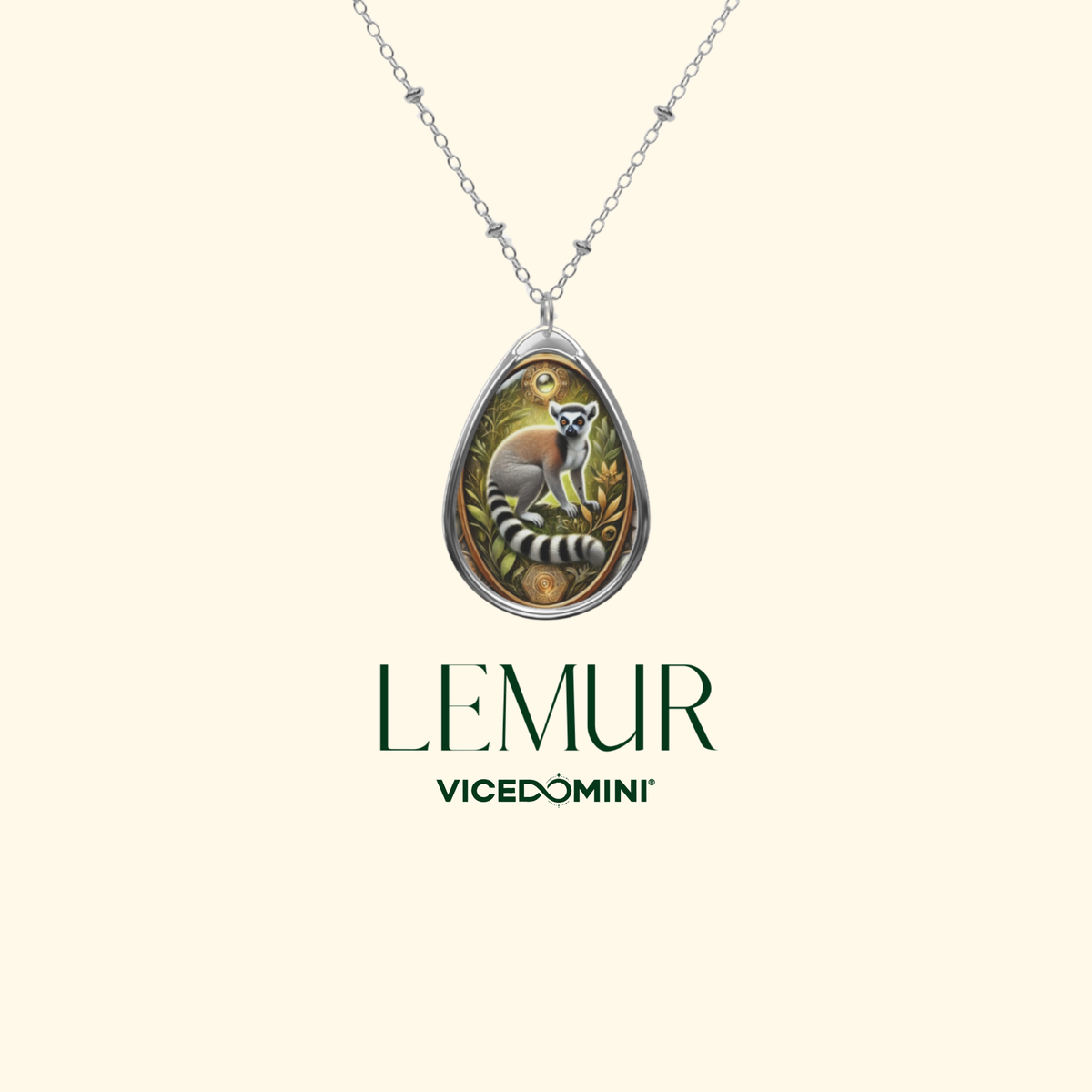 A silver teardrop pendant necklace featuring an illustrated lemur, shown against a light cream background with the brand name 'LEMUR' and 'VICEDOMINI' printed below.