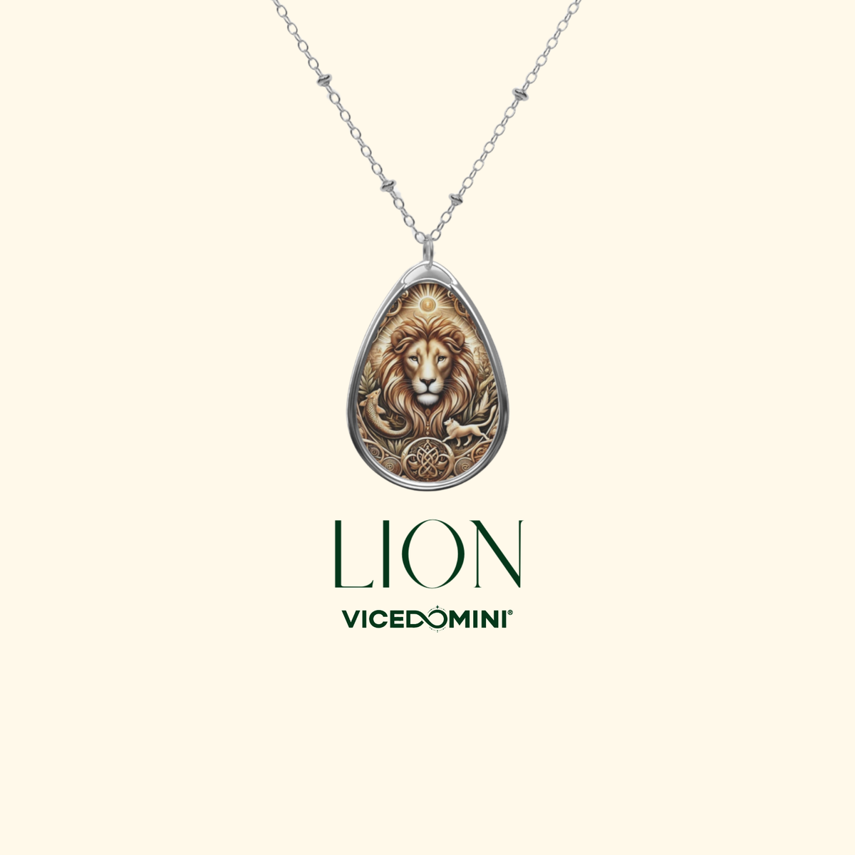 A silver teardrop pendant necklace featuring an embossed lion head design, shown on a light cream background with the brand name 'VICEDOMINI' and the word 'LION' printed below.