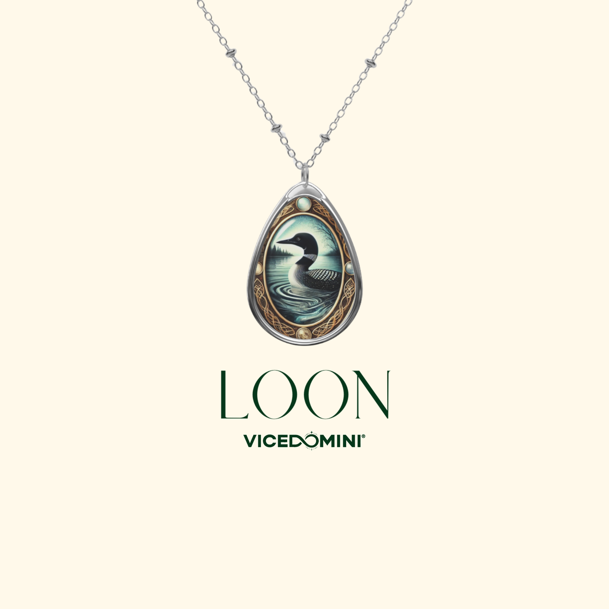 A silver teardrop pendant necklace featuring a detailed illustration of a swan over rippling water, with the brand name 'LOON VICEDOMINI' printed below on a light cream background.
