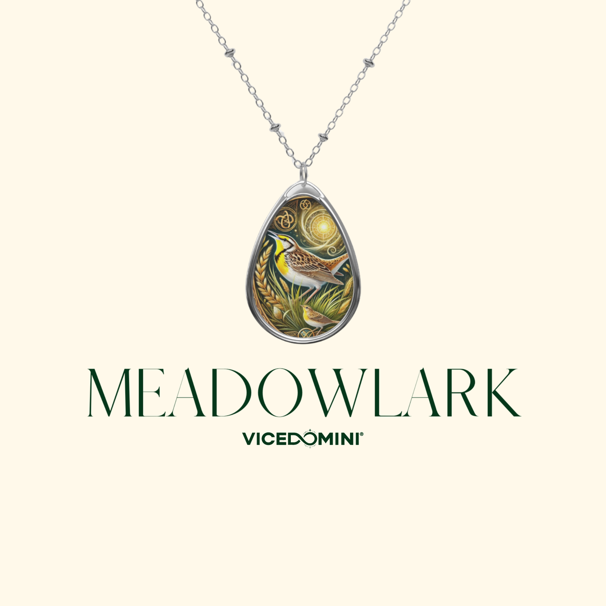A silver teardrop pendant necklace featuring an intricate illustration of a bird and natural elements, displayed against a cream background with the brand name 'MEADOWLARK' and sub-brand 'VICEDOMINI' printed below.