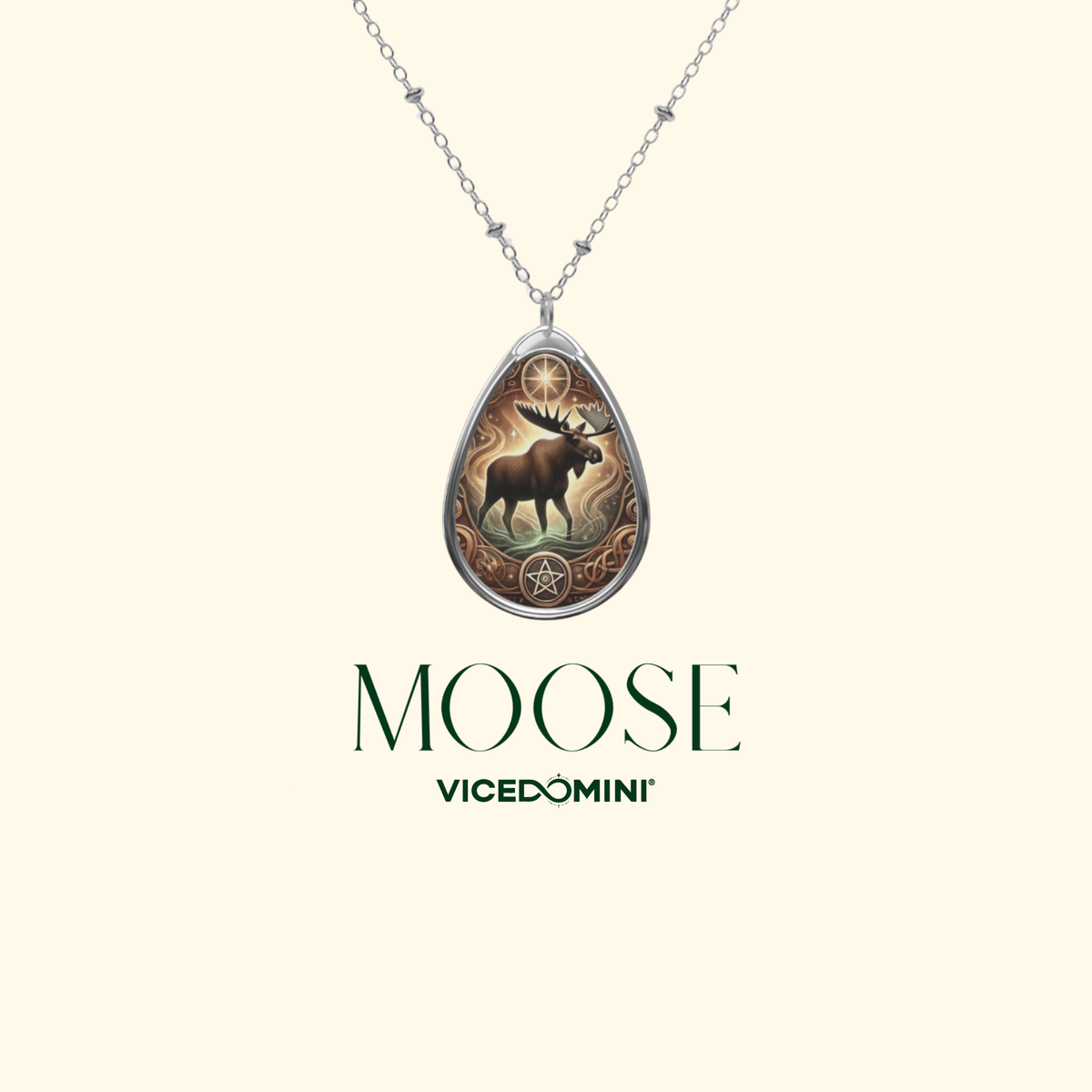 A silver teardrop pendant necklace featuring an illustrated moose and star design, shown against a light cream background with the brand name 'MOOSE VICEDOMINI' printed below.