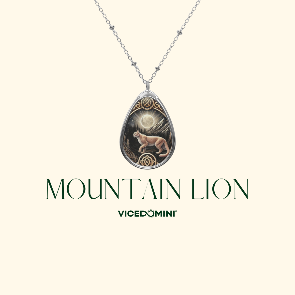 A silver teardrop pendant necklace featuring an engraved mountain lion under a full moon, shown on a light cream background with the text 'MOUNTAIN LION' and 'VICEDOMINI' below.