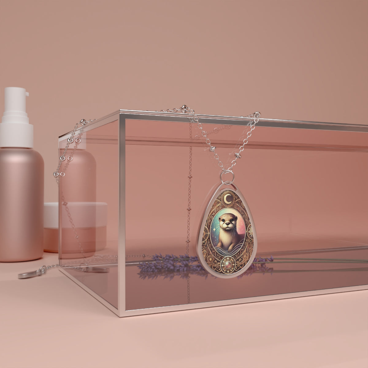 The Otter pendant necklace draped over a sleek, transparent display box on a minimalist vanity setting. The pendant's filigree and celestial-inspired design elements stand out, with a delicate silver chain elegantly arranged. The soft, neutral-toned background enhances the luxurious feel.