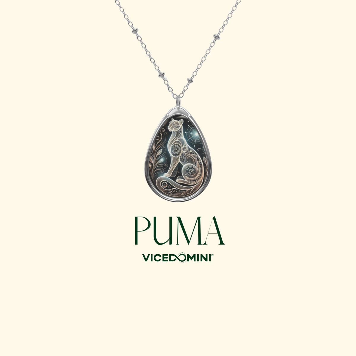 A teardrop-shaped pendant with an artistic depiction of a puma in an intricate, swirling style. The necklace hangs against a minimalist cream-colored background, with "PUMA" and "VICEDOMINI" written beneath.