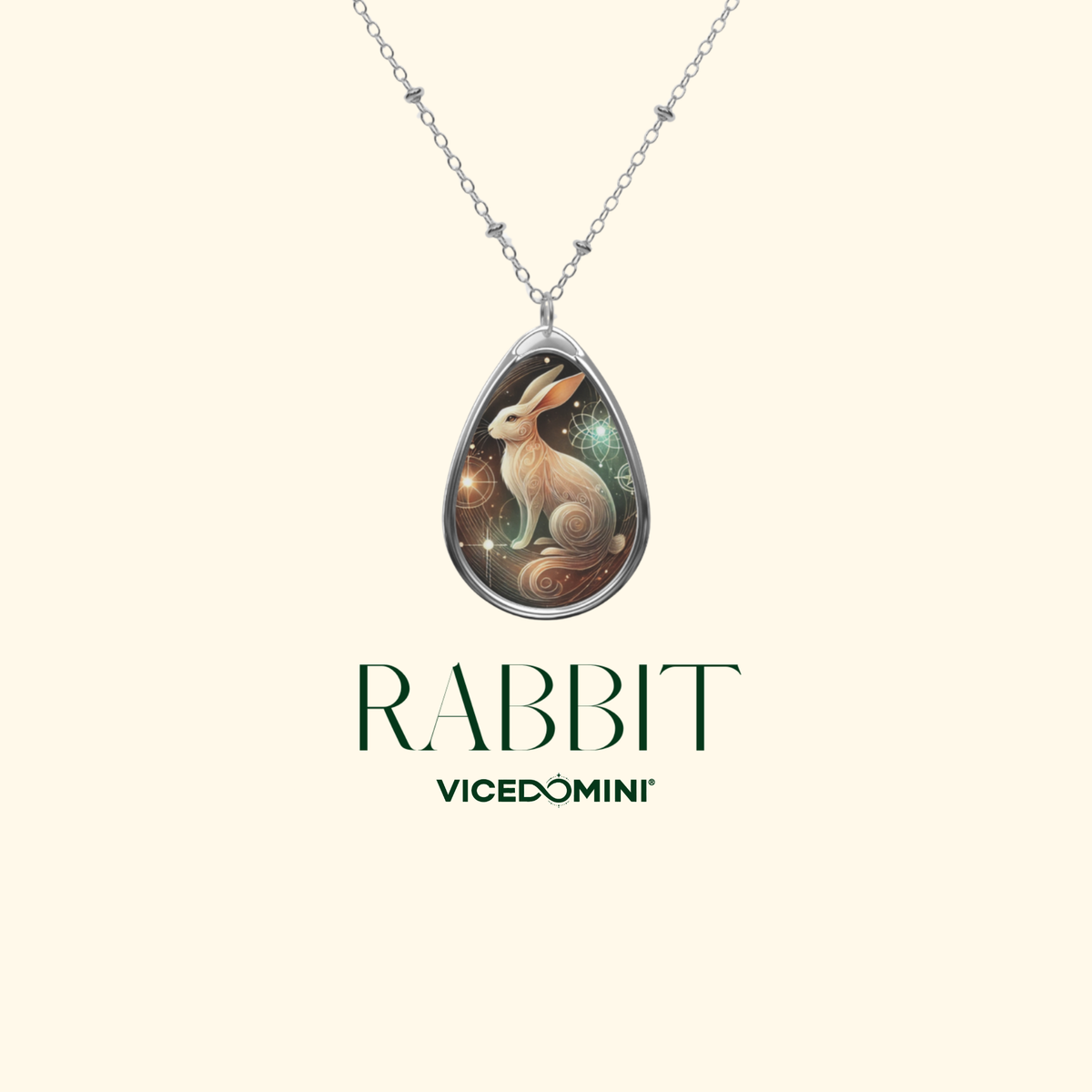 A rabbit-themed pendant necklace with an artistic, mystical design, suspended from a fine silver chain, set against a minimalist cream-colored background with the text "RABBIT" and "VICEDOMINI."