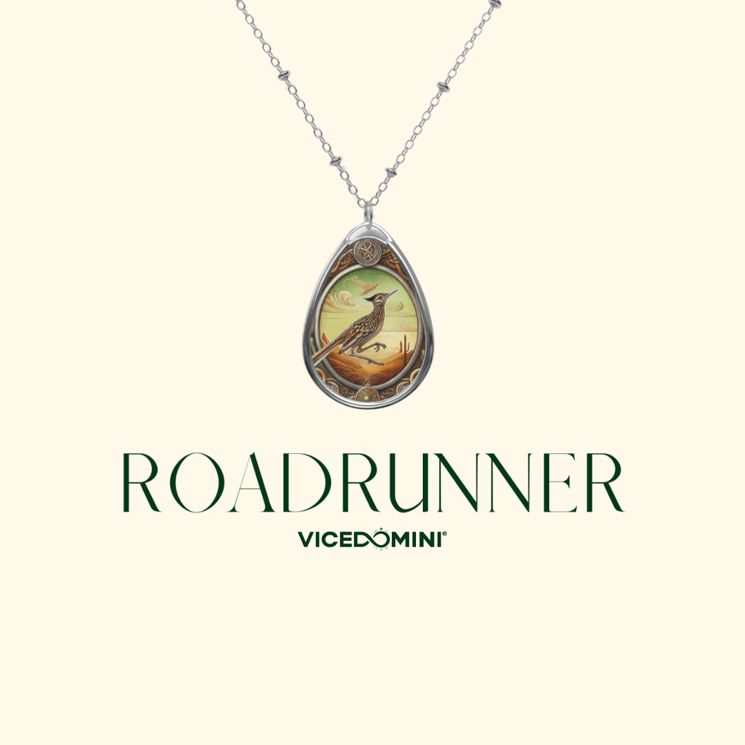 A silver-toned teardrop pendant necklace featuring a colorful illustration of a bird on a branch, displayed against a light cream background with the text 'ROADRUNNER' and 'VICEDOMINI' below.