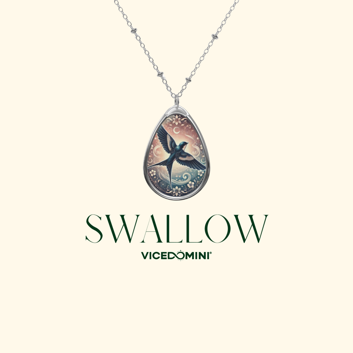 A teardrop-shaped pendant necklace featuring a detailed swallow illustration with a silver-toned chain, displayed on a light cream background with the brand name 'VICEDOMINI' and 'SWALLOW' printed below.