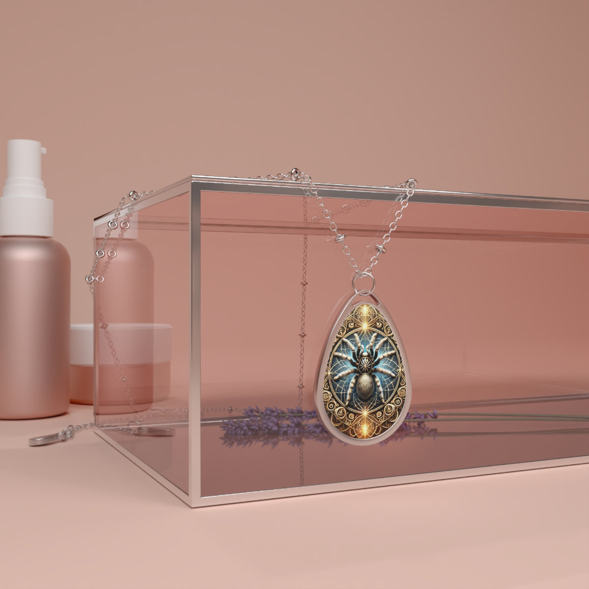 The teardrop-shaped tarantula pendant draped over a glass jewelry box with soft pink hues, surrounded by lavender flowers and cosmetic bottles. The pendant's intricate golden frame and vibrant blue spider create a bold contrast.