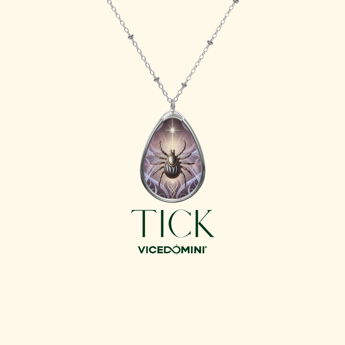 A silver teardrop pendant necklace featuring a detailed illustration of a beetle on a web with a glowing star, displayed on a cream background with the brand name 'VICEDOMINI' and collection name 'TICK'.