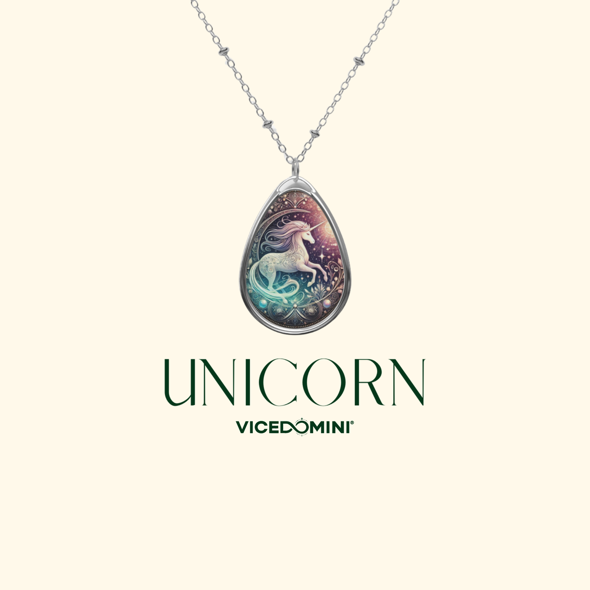 A silver teardrop pendant necklace featuring an illustrated unicorn on a colorful cosmic background, displayed against a light cream background with the text 'UNICORN VICEDOMINI' below.