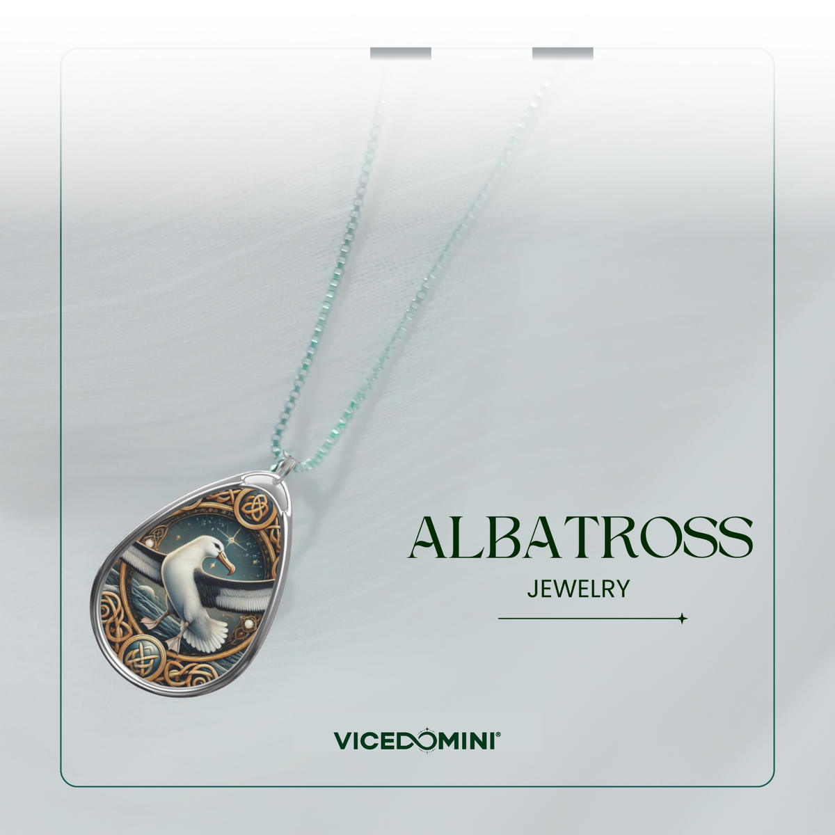A teardrop-shaped pendant necklace from Vicedomini Albatross Jewelry, featuring a silver-toned frame with an intricate illustration of an albatross and sea creatures, suspended from a delicate mint green chain against a light gray background.