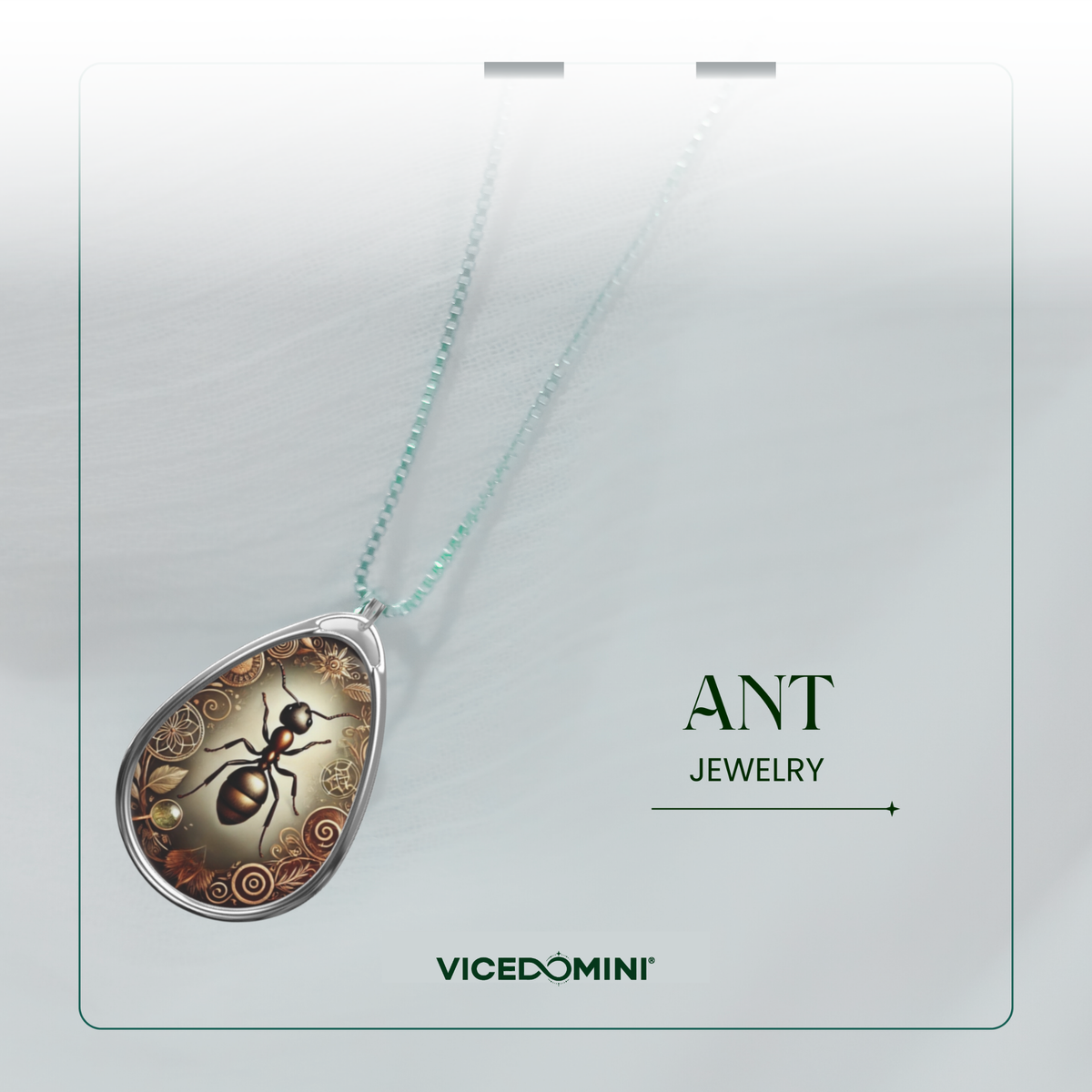 A Vicedomini necklace with a teardrop-shaped pendant featuring a detailed ant illustration on a gold-toned background, suspended from a light aqua chain, presented on a white card labeled 'ANT JEWELRY' and 'VICEDOMINI'.