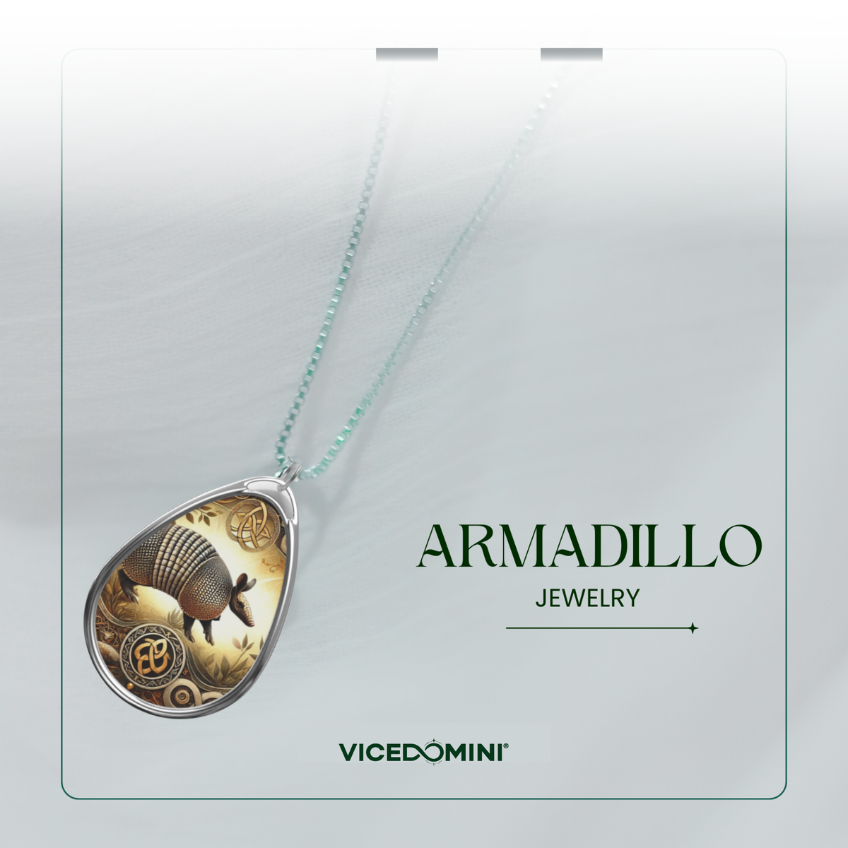 Teardrop-shaped pendant necklace featuring a detailed armadillo illustration with gold and brown tones, suspended on a delicate mint green chain. The necklace is presented on a white display card with the text 'ARMADILLO JEWELRY' and the brand 'VICEDOMINI'.