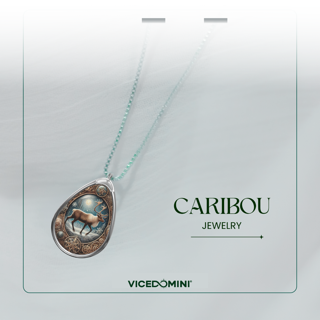 A teardrop-shaped pendant necklace from Vicedomini's Caribou Jewelry collection, featuring a detailed caribou illustration on a silver-toned background with a light aqua chain, presented on a white display card.