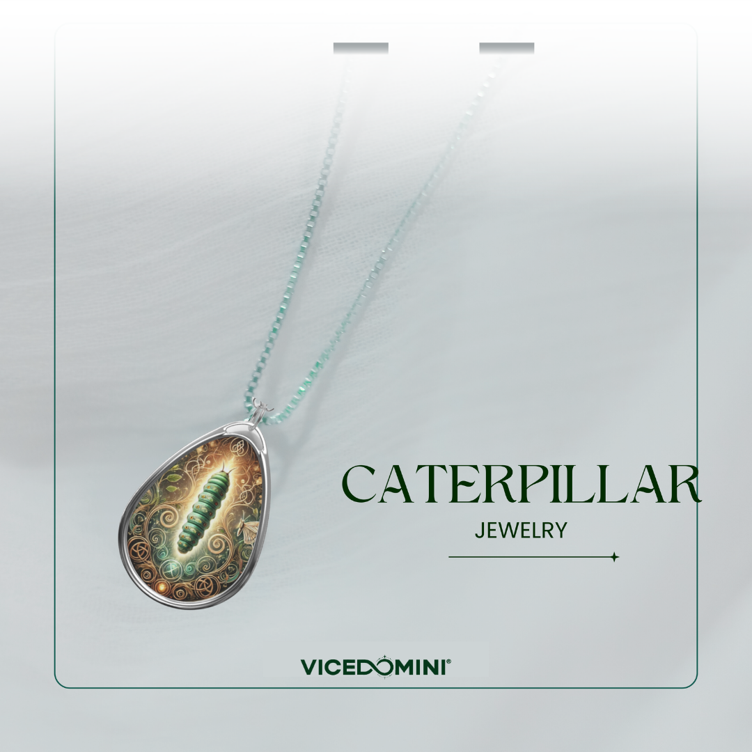 A teardrop-shaped pendant necklace on a silver chain, featuring a green caterpillar illustration over an ornate gold and green patterned background. The pendant is displayed on a light gray card with the text 'CATERPILLAR JEWELRY' and the brand 'VICEDOMINI'.