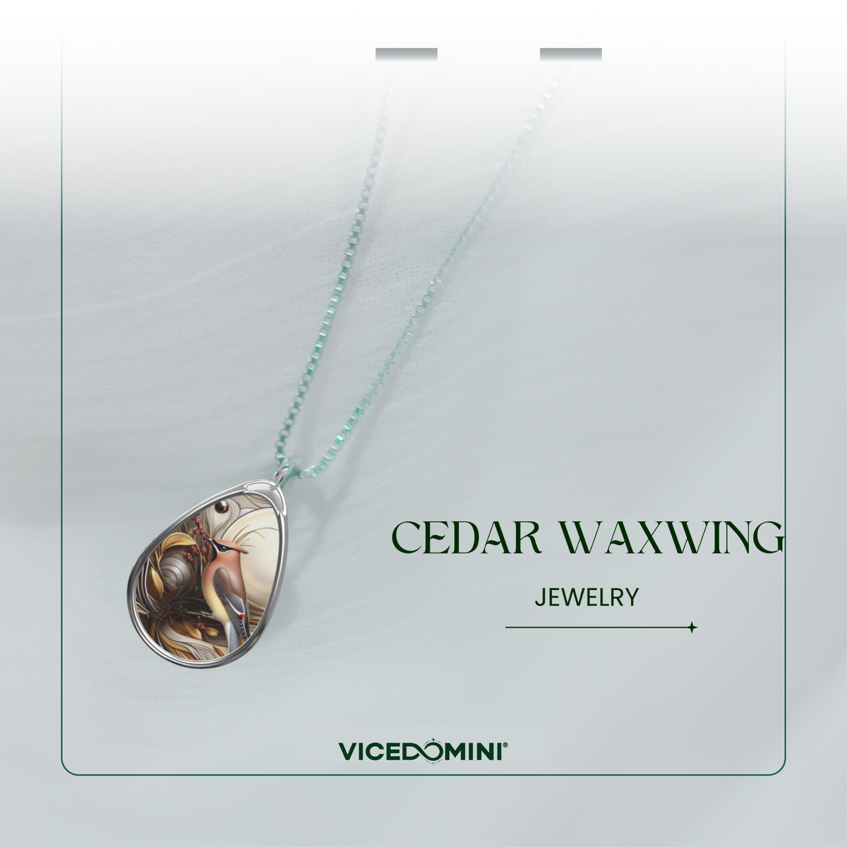 A teardrop-shaped pendant necklace with a detailed waxwing bird design, hanging from a light mint-green chain. The pendant is displayed on a white card labeled 'CEDAR WAXWING JEWELRY' by the brand 'VICEDOMINI'.