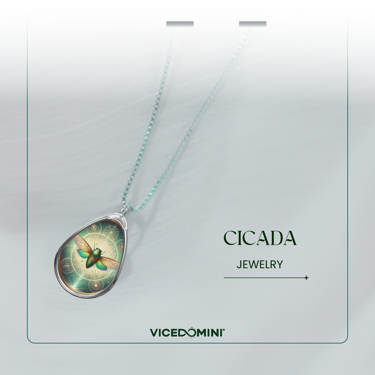 A teardrop-shaped pendant necklace with a green and gold cicada design, suspended on a light mint-green chain. The necklace is presented on a white display card with the brand name 'VICEDOMINI' and collection name 'CICADA JEWELRY'.