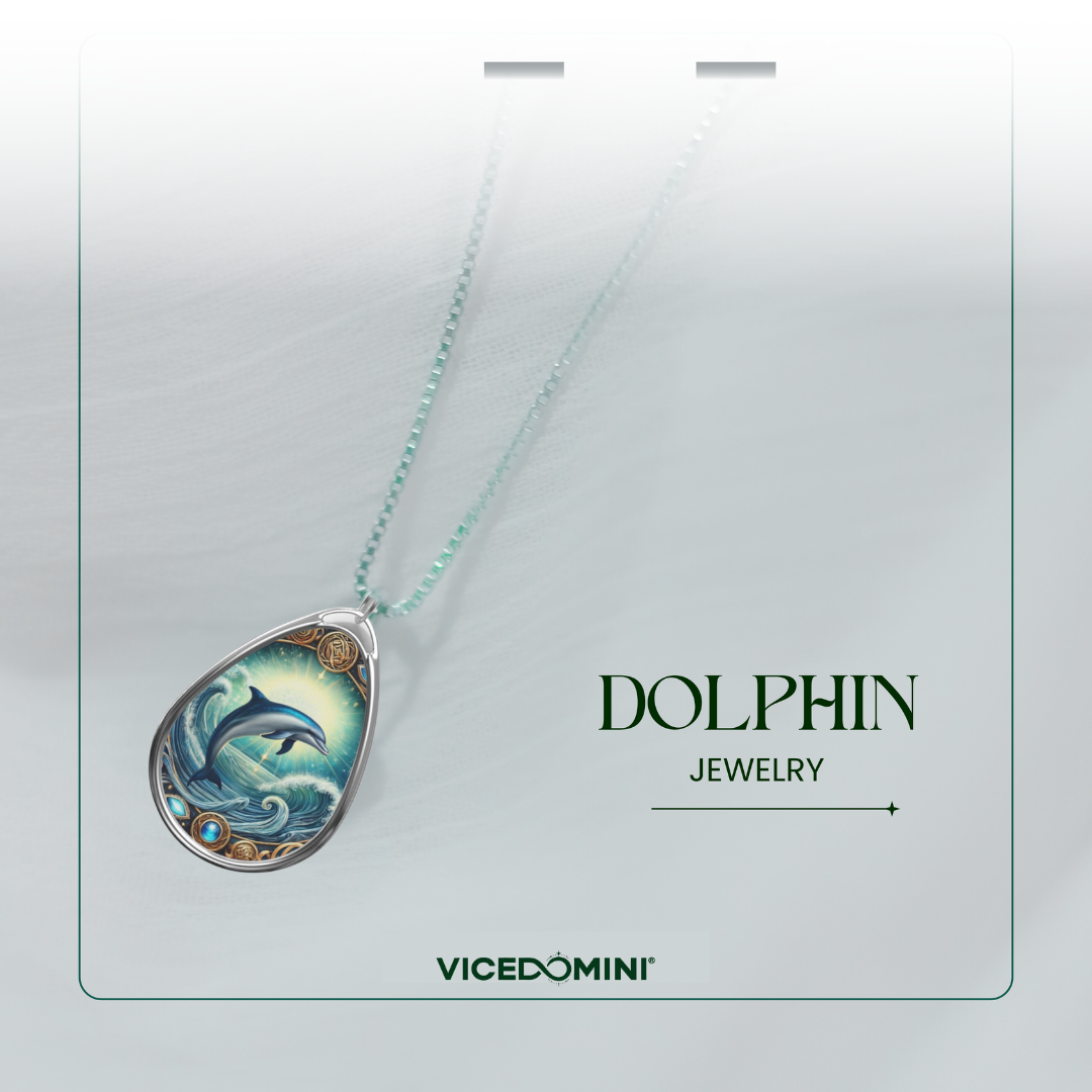 A teardrop-shaped pendant necklace on a light mint chain, featuring an illustrated dolphin and ocean scene. The pendant is displayed on a branded card that reads 'DOLPHIN JEWELRY' and 'VICEDOMINI'.