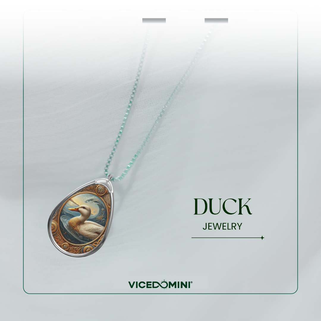 A teardrop-shaped pendant necklace from Vicedomini Duck Jewelry, featuring a detailed illustration of a duck in a natural pond scene, suspended on a delicate light green chain against a soft gray background.