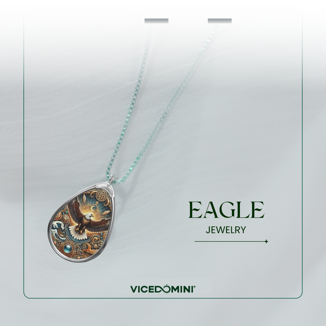 A Vicedomini Eagle Jewelry pendant necklace displayed on a light gray card. The teardrop-shaped pendant features a detailed illustration of an eagle in gold, brown, and blue tones, suspended from a delicate light blue-green chain.