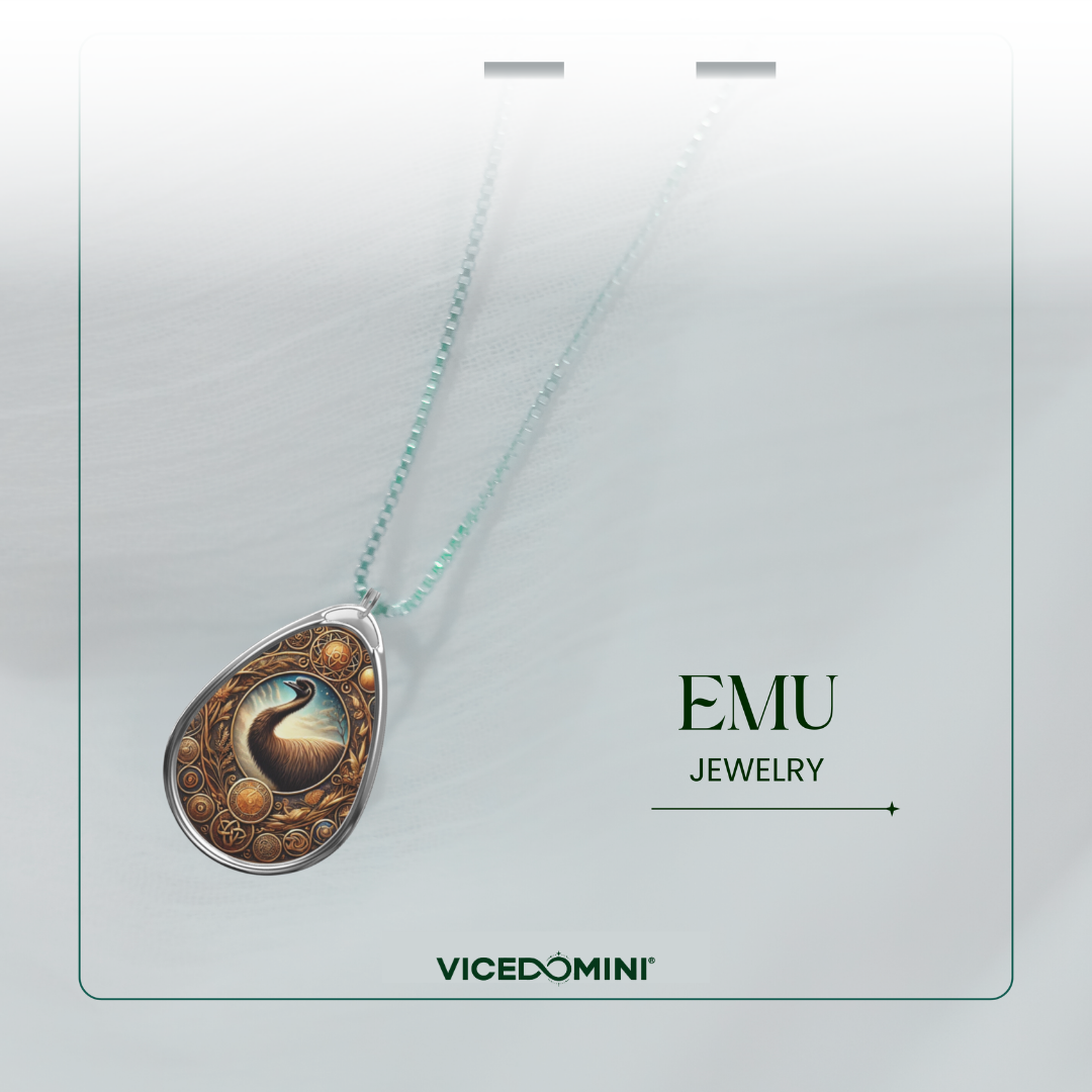 Teardrop pendant necklace with a detailed phoenix design and gold circular accents, hanging on a delicate mint green chain against a light gray background with 'EMU JEWELRY' and 'VICEDOMINI' branding.
