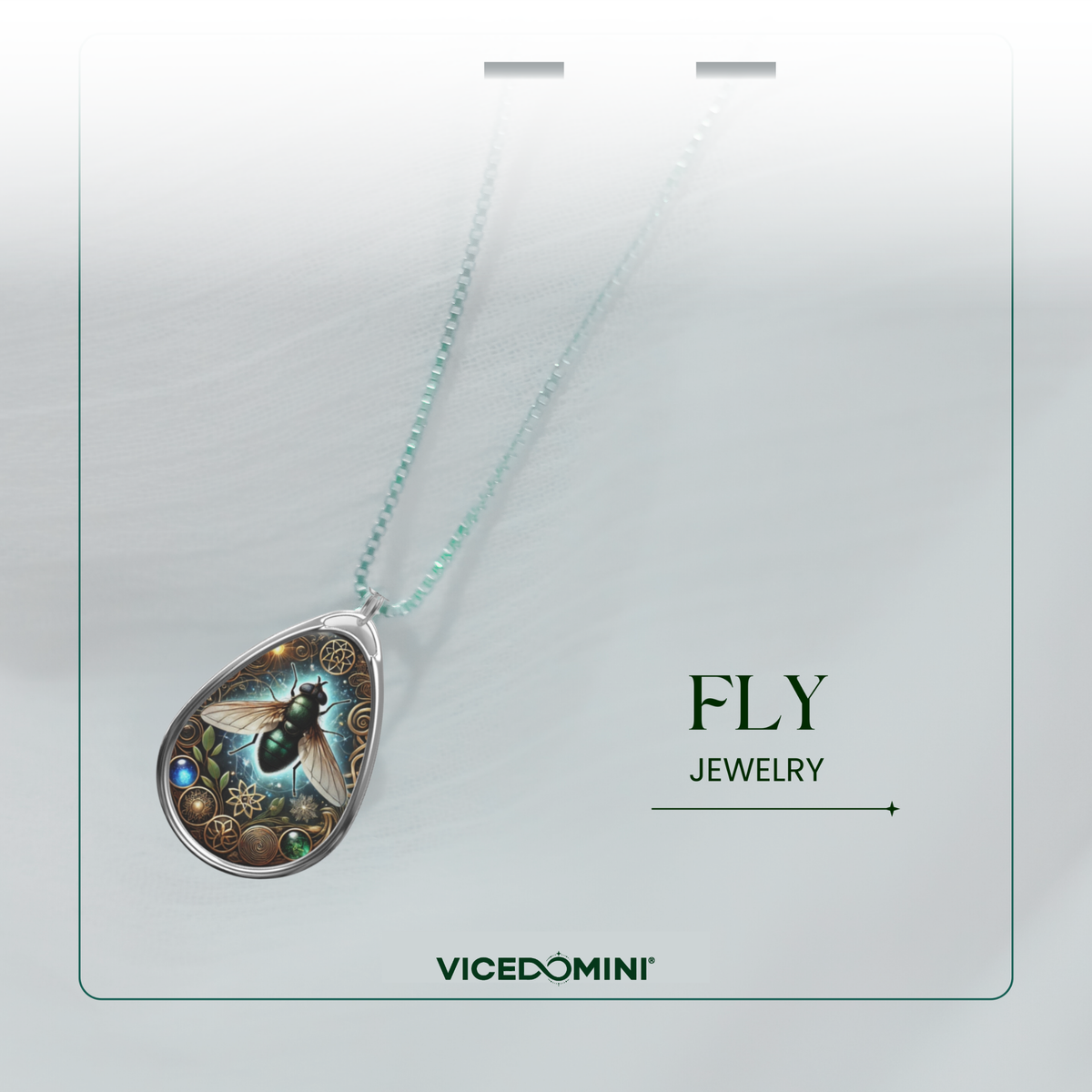 A teardrop-shaped pendant necklace from Vicedomini, featuring a detailed fantasy illustration of a green dragonfly with gold gears and a light blue chain, displayed on a light gray textured card with 'FLY JEWELRY' text.