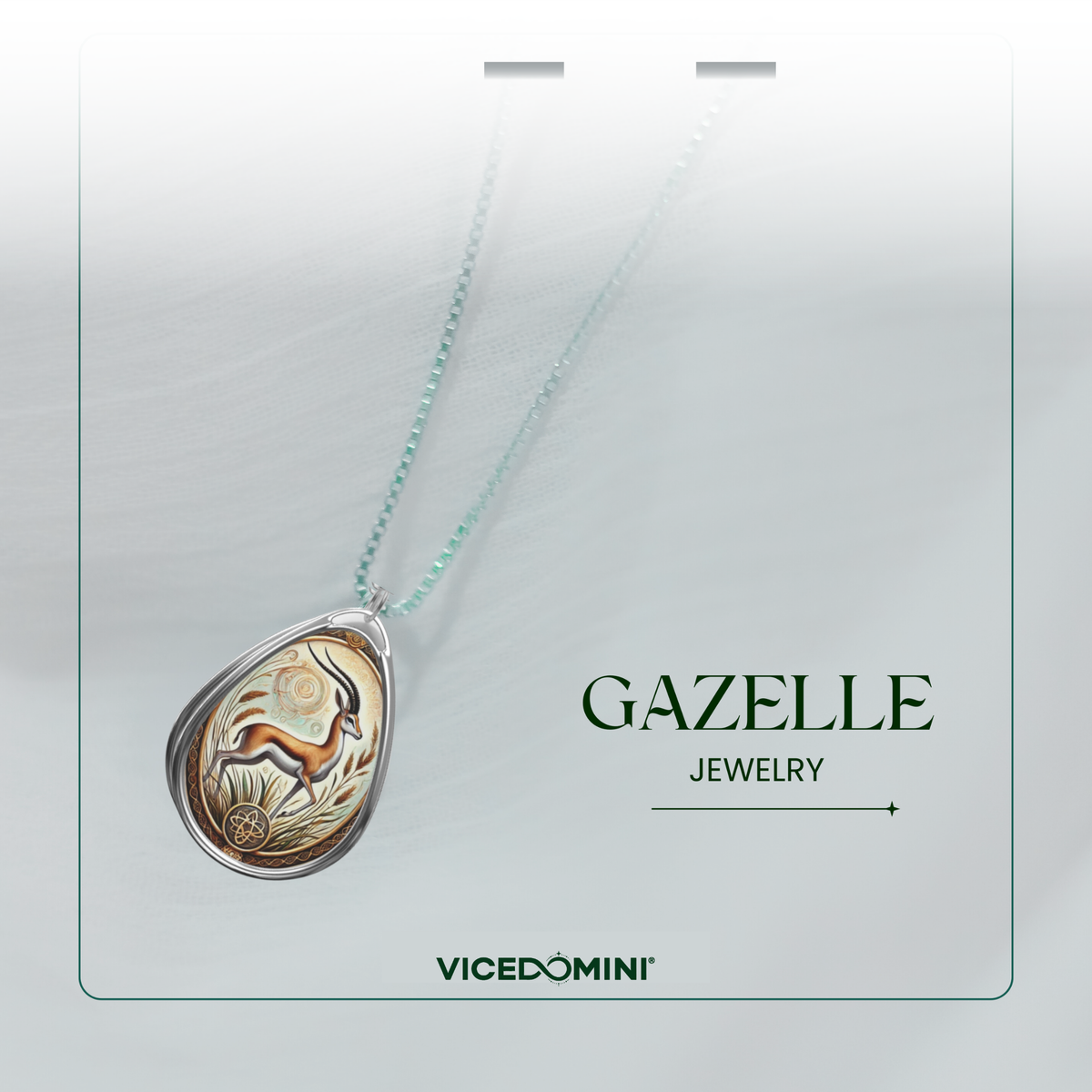 A teardrop-shaped pendant necklace on a matching chain, featuring a detailed gazelle illustration in warm gold, brown, and beige tones, set in a silver-toned bezel. The necklace is presented on a light gray display card with the text 'GAZELLE JEWELRY' and the brand 'VICEDOMINI'.