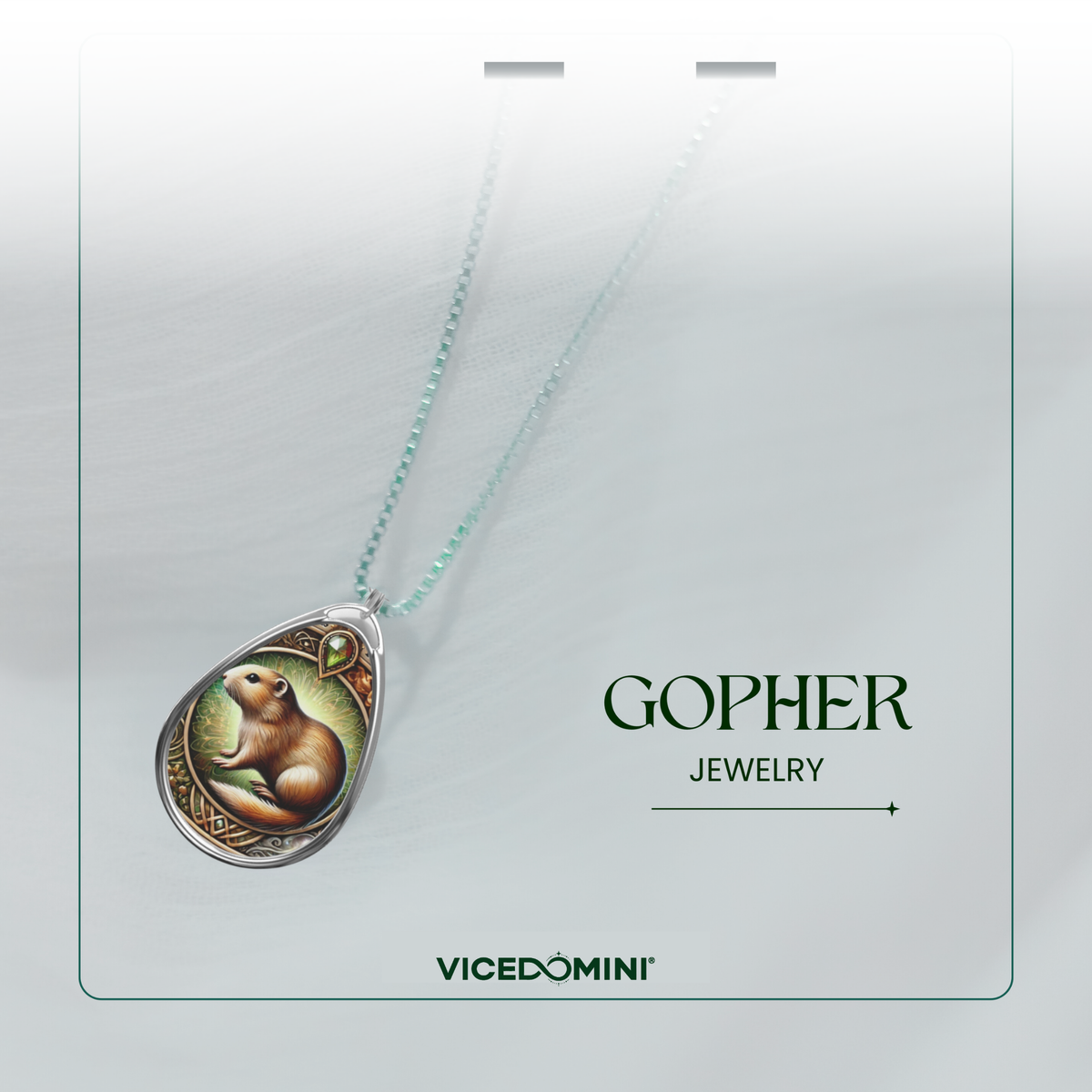 A teardrop-shaped pendant necklace featuring an illustrated brown gopher on a light green background, suspended from a delicate mint-green chain. The pendant is displayed on a white card with the brand name 'GOPHER JEWELRY' and the line 'VICEDOMINI' printed on it.