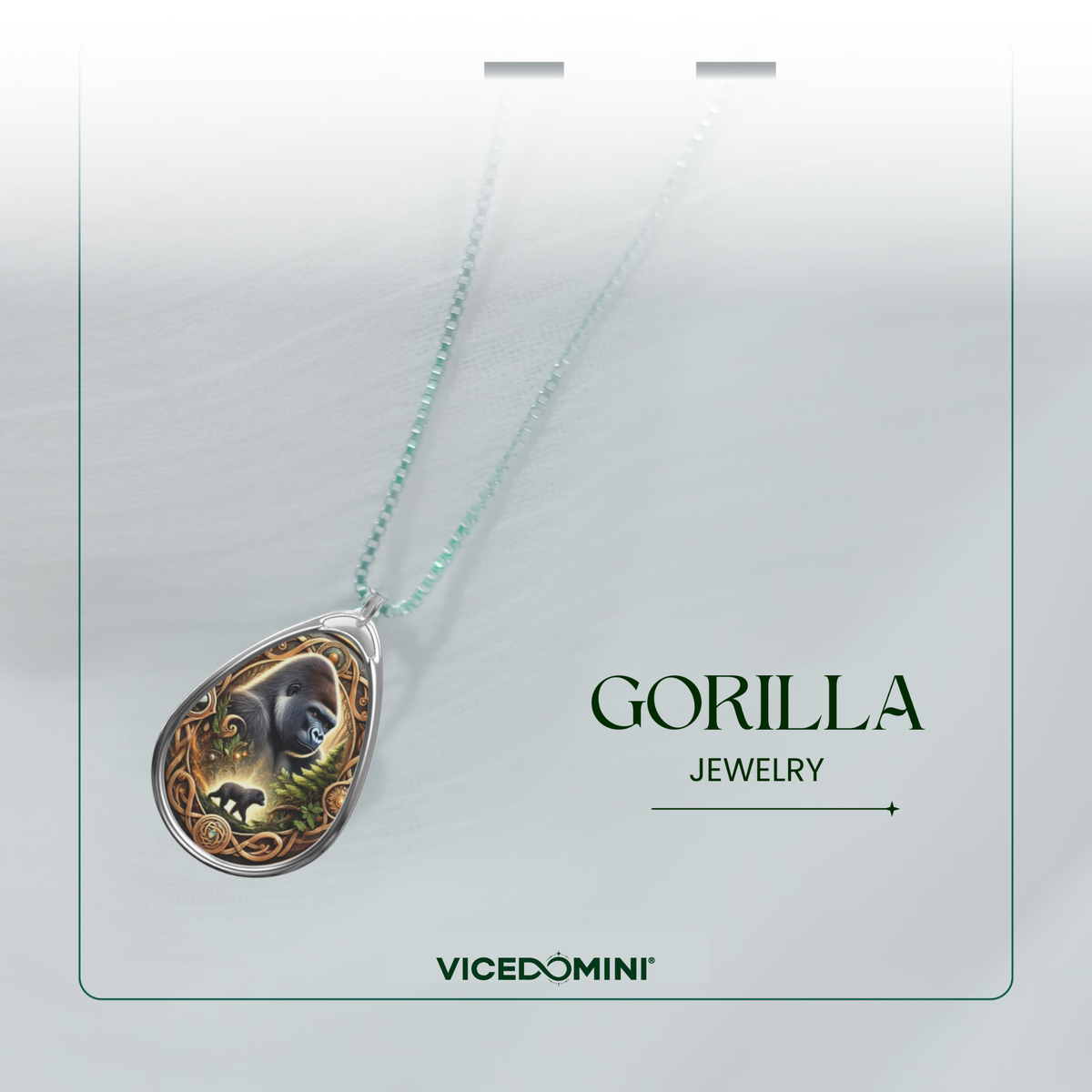 A teardrop-shaped pendant necklace from Vicedomini Gorilla Jewelry, featuring a detailed gorilla illustration with green and gold accents on a silver-toned setting, suspended from a light mint-green chain against a light gray background.