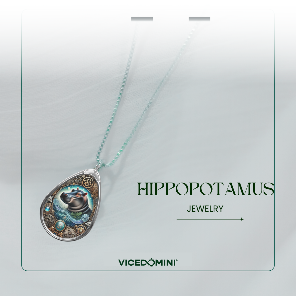 A teardrop-shaped pendant necklace with a detailed hippopotamus illustration and silver-toned gears, hanging from a light mint-green chain on a white display card. The card features the text 'HIPPOPOTAMUS JEWELRY' and the brand 'VICEDOMINI'.