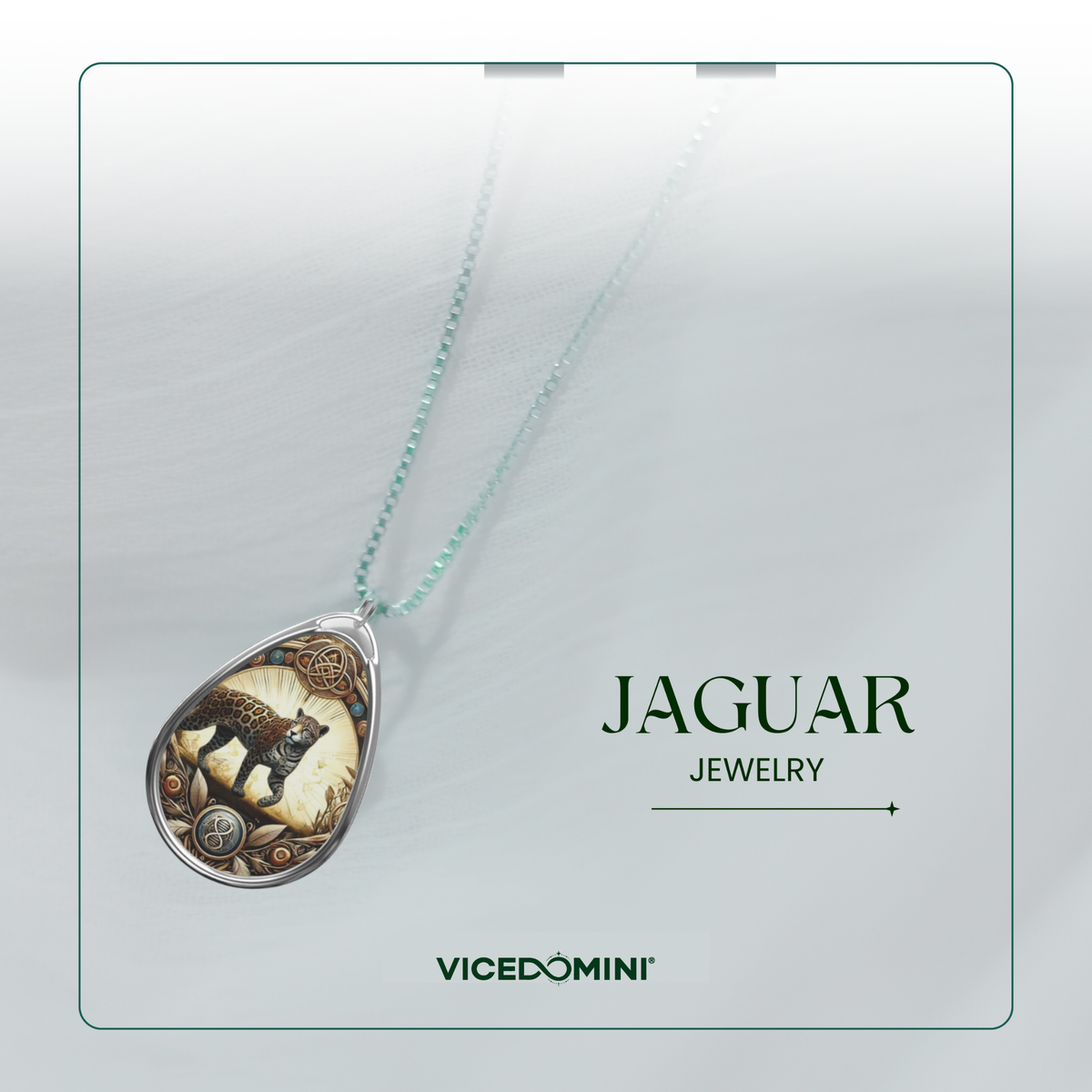 A teardrop-shaped pendant necklace from Vicedomini's Jaguar Jewelry collection, featuring a detailed black and brown jaguar illustration on a cream background with gold-toned gears, suspended from a light mint-green chain.