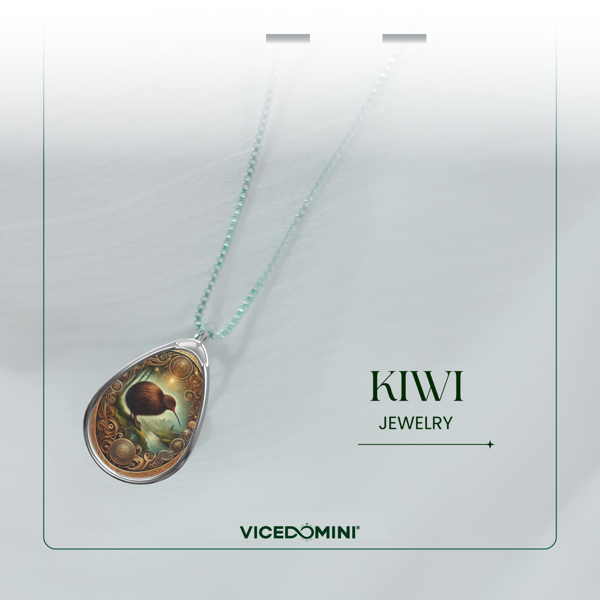 A teardrop-shaped pendant necklace from Vicedomini's Kiwi Jewelry collection, featuring a detailed fantasy illustration of a kiwi fruit on a silver-toned chain against a light gray background.