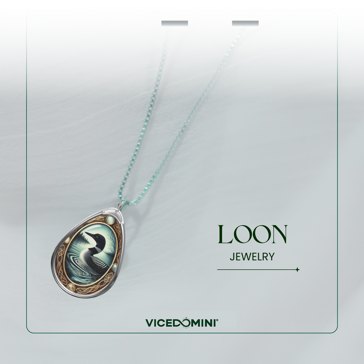 A teardrop pendant necklace from Vicedomini Loon Jewelry, featuring a detailed illustration of a loon in a light blue-green water scene with a gold border, suspended on a delicate light blue-green chain against a soft gray background.