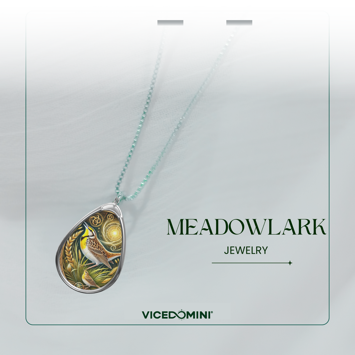 A teardrop-shaped pendant necklace from Meadowlark Jewelry by Vicedomini, featuring a detailed bird illustration on a silver-toned background with a light aqua chain, displayed on a white card.