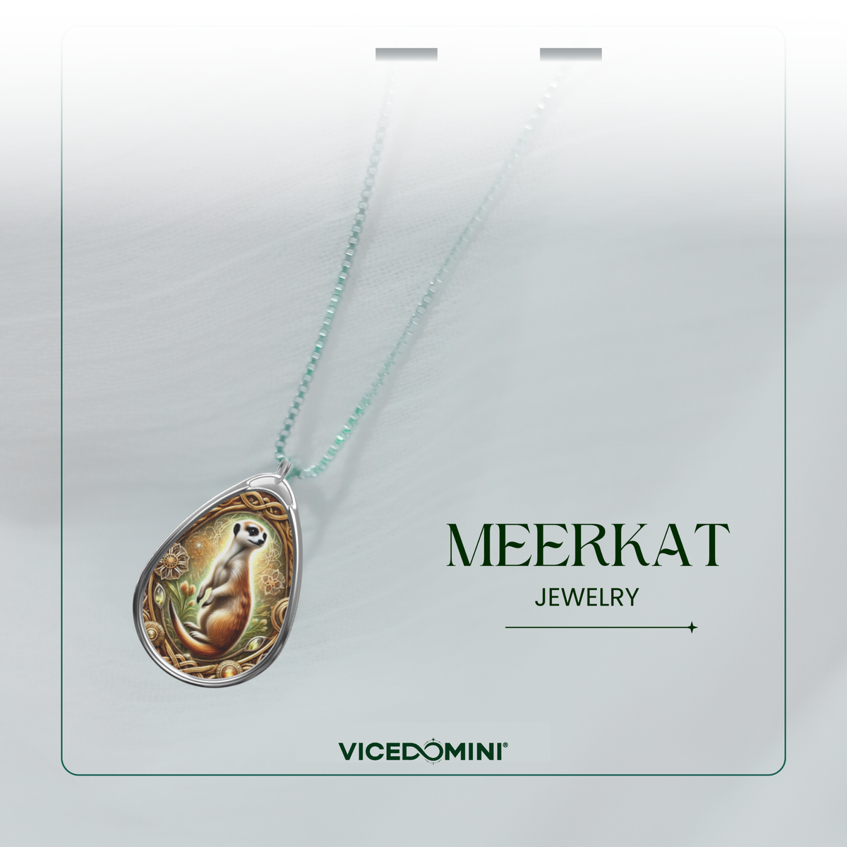 A teardrop-shaped pendant necklace featuring an illustrated meerkat on a light mint-green chain, displayed on a white card with the text 'MEERKAT JEWELRY' and the brand 'VICEDOMINI'.