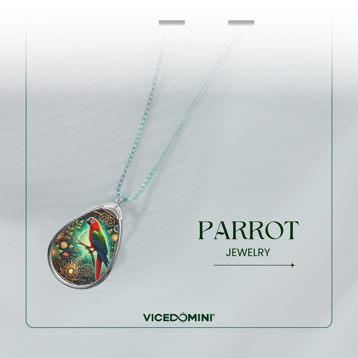 A teardrop-shaped pendant necklace from Vicedomini, featuring a colorful parrot illustration on a silver-toned frame, suspended from a light mint-green beaded chain. The necklace is displayed on a white card with the text 'PARROT JEWELRY' and the brand 'VICEDOMINI'.