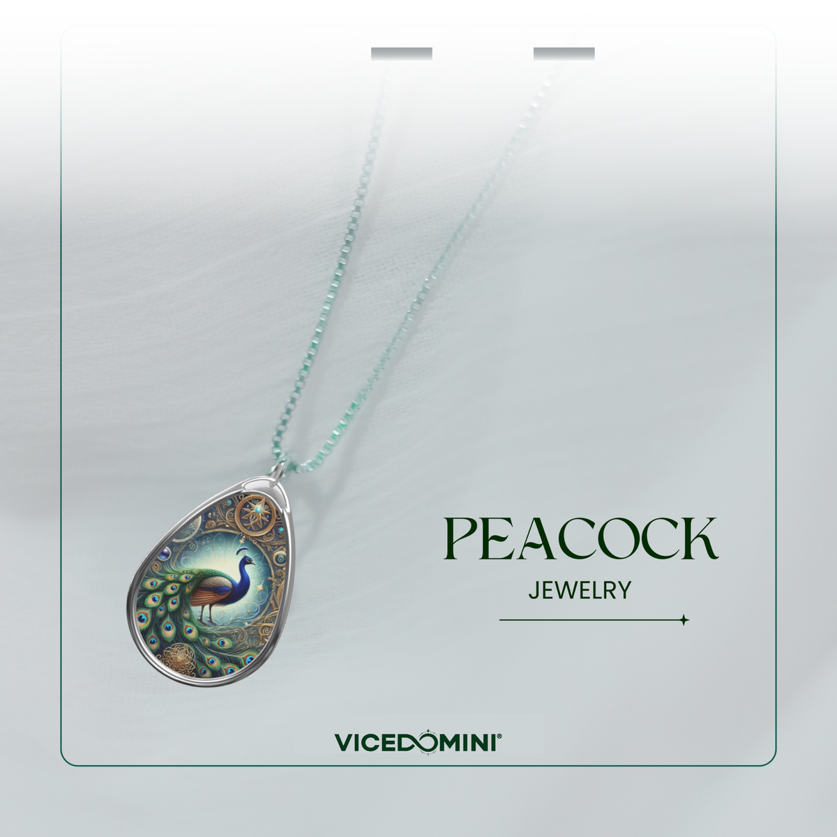 A teardrop-shaped pendant necklace on a matching chain, featuring an intricate peacock illustration with a silver-toned border and decorative details. The necklace is displayed on a light gray card with the text 'PEACOCK JEWELRY' and the brand 'VICEDOMINI'.