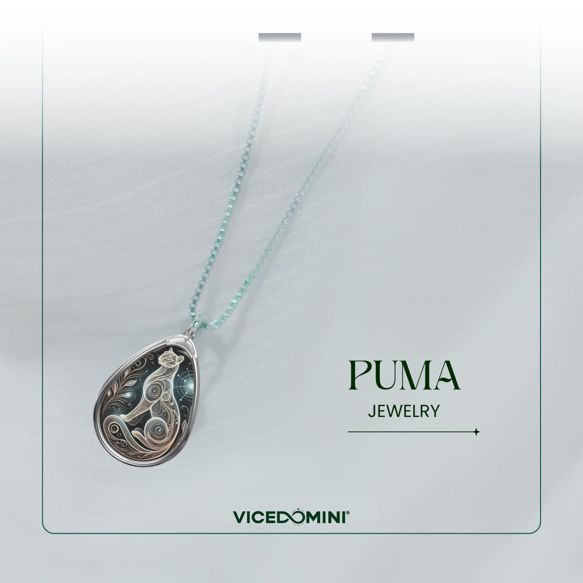 A close-up of a puma-themed pendant necklace, suspended on a delicate chain against a soft, blurred white fabric. The pendant features a mystical swirling puma design with celestial details. The text "PUMA JEWELRY" and "VICEDOMINI" is elegantly placed.