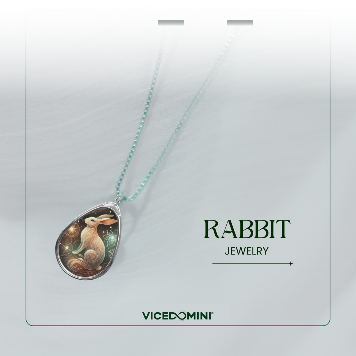 A close-up of the rabbit pendant necklace with its delicate silver chain, displayed against a soft, airy white background. The text "RABBIT JEWELRY" and "VICEDOMINI" is elegantly framed.