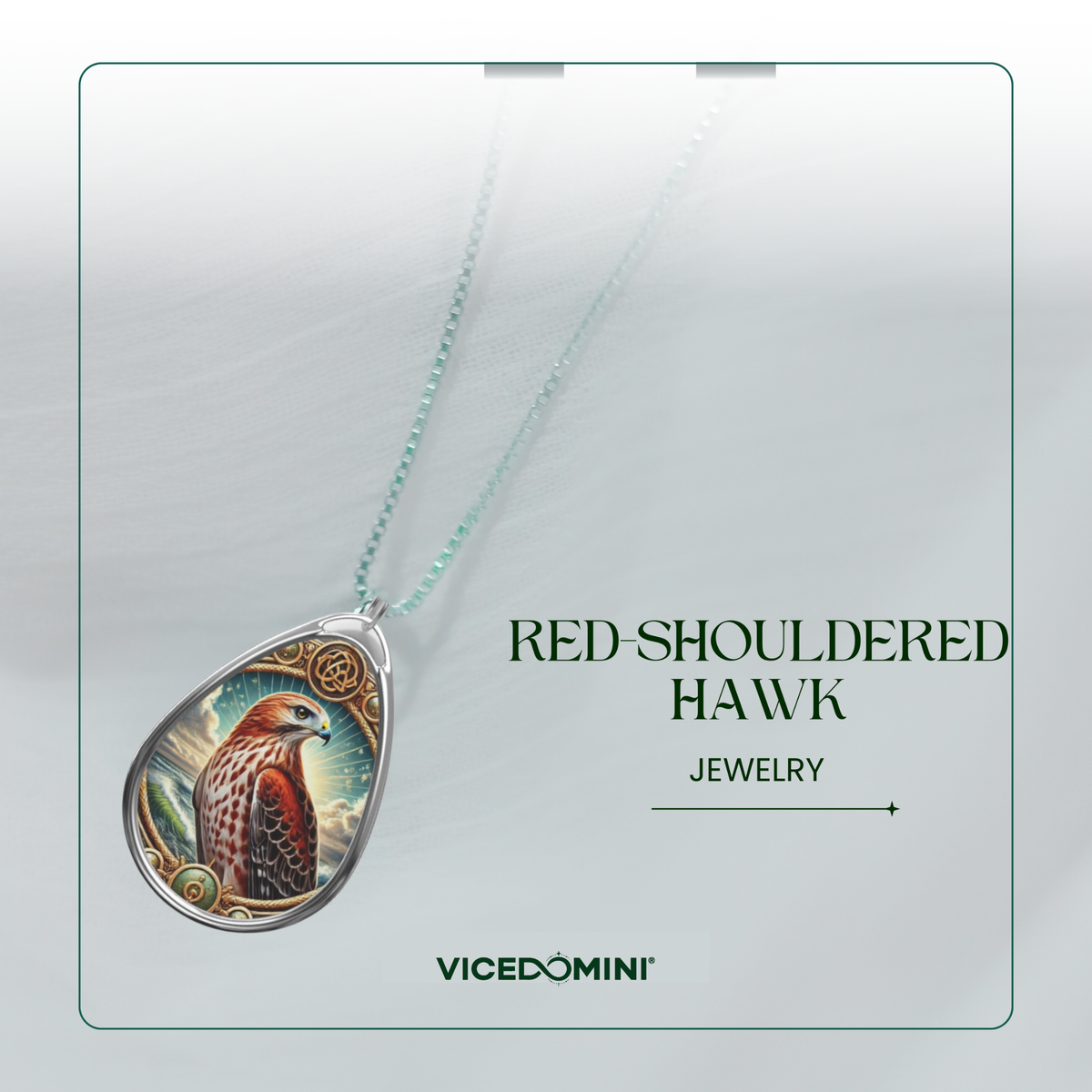 A teardrop-shaped pendant necklace featuring a detailed illustration of a red-shouldered hawk, suspended from a delicate mint-green chain. The pendant is displayed on a light gray textured background with elegant typography that reads 'RED-SHOULDERED HAWK JEWELRY' and the brand 'VICEDOMINI'.