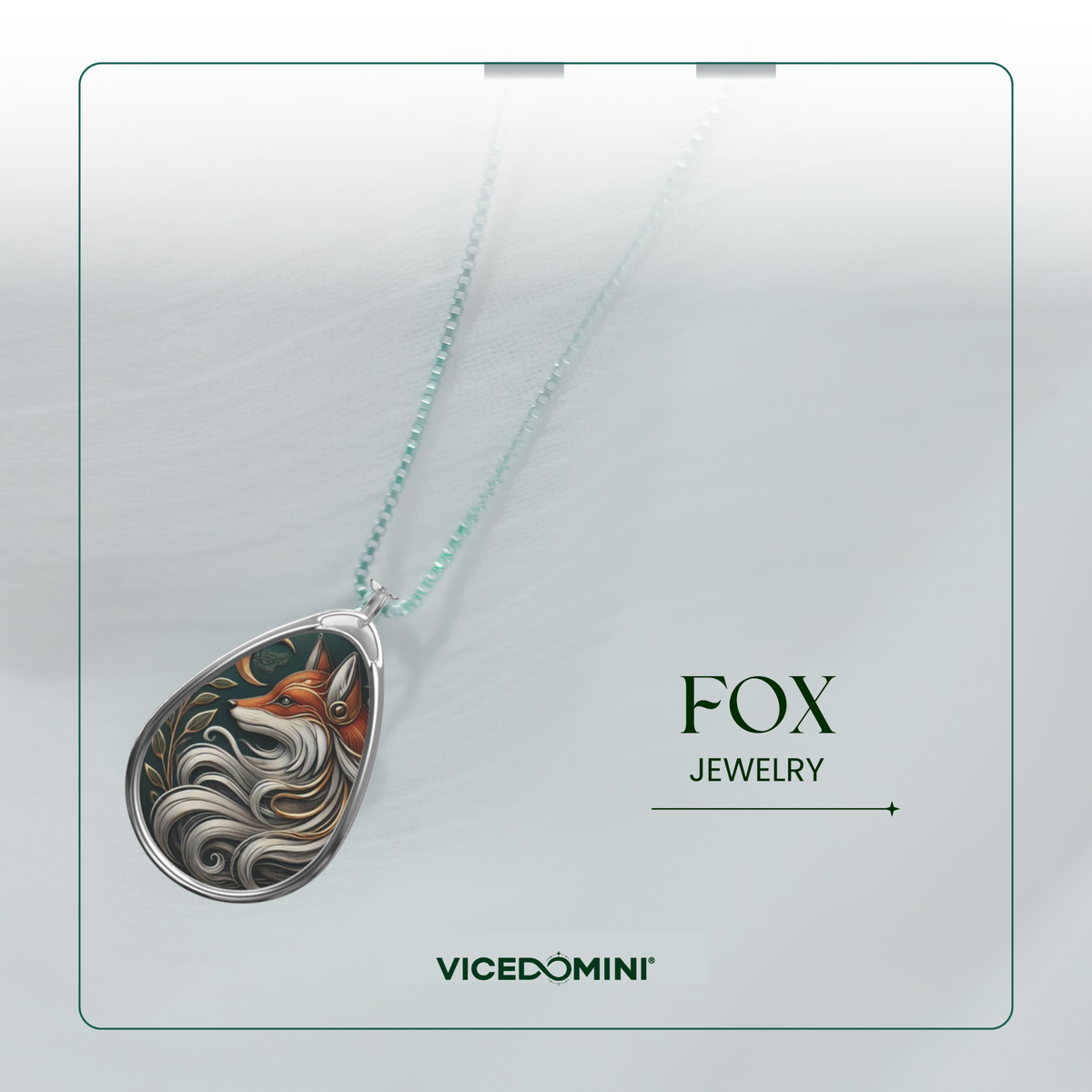 A teardrop-shaped pendant necklace from Vicedomini Fox Jewelry, featuring a detailed silver-toned fox design with orange, white, and black swirls, suspended on a delicate mint green chain against a light gray background with brand text.