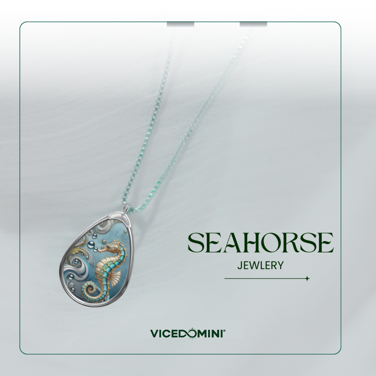 A teardrop-shaped pendant necklace featuring an intricately designed seahorse motif in shades of blue, teal, and gold, suspended from a delicate light green chain. The pendant is displayed against a soft, light gray textured background with branding text 'SEAHORSE JEWELRY' and 'VICEDOMINI' on the right side.