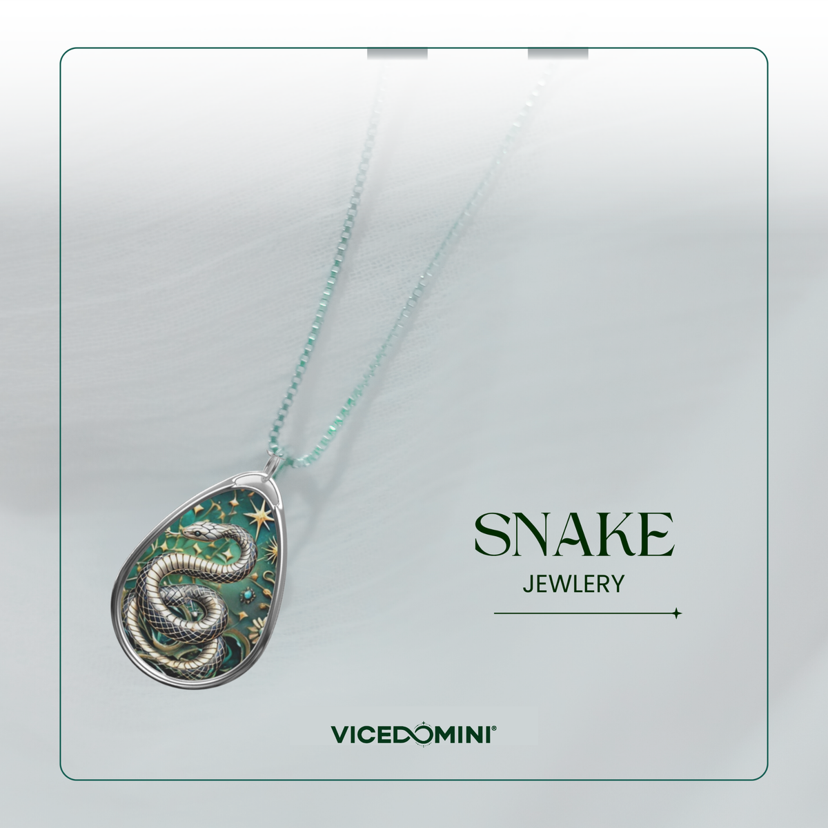 A teardrop-shaped pendant necklace featuring a detailed silver snake design with green and gold accents, suspended on a delicate mint green chain. The pendant is displayed against a soft, light gray background with a thin green border, alongside the text 'SNAKE JEWELRY' and the brand name 'VICEDOMINI'.