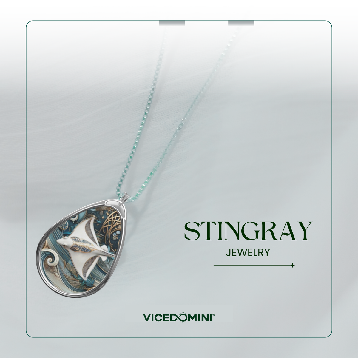 A teardrop-shaped pendant necklace featuring a silver-toned stingray design with blue, teal, and gold details, suspended on a delicate mint-green chain. The pendant is displayed against a light gray textured background with a thin teal border, alongside the text 'STINGRAY JEWELRY' and the brand 'VICEDOMINI'.