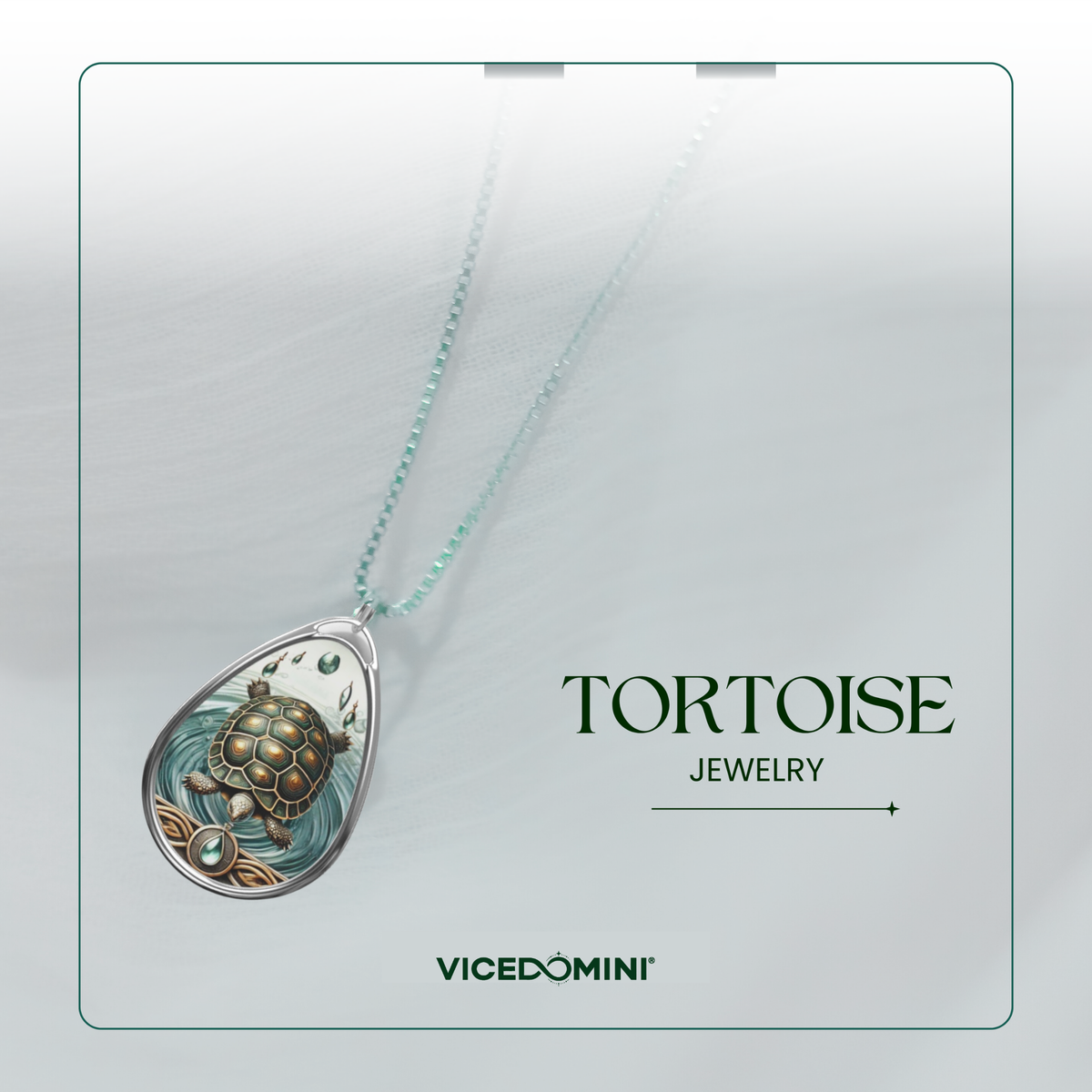 A teardrop-shaped pendant necklace featuring a detailed turtle design in green, gold, and silver tones, suspended from a light mint-green chain. The necklace is displayed on a light gray textured background with the text 'TORTOISE JEWELRY' and the brand 'VICEDOMINI' printed below.